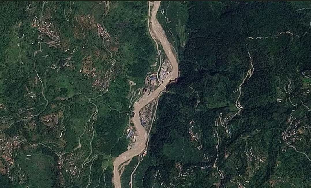 Satellite view of a Himalayan river valley with terraced hillsides, settlements and a wide pale river channel