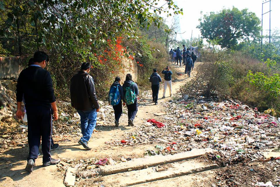 Placeholder frame: walkers on a footpath thickly littered with plastic waste