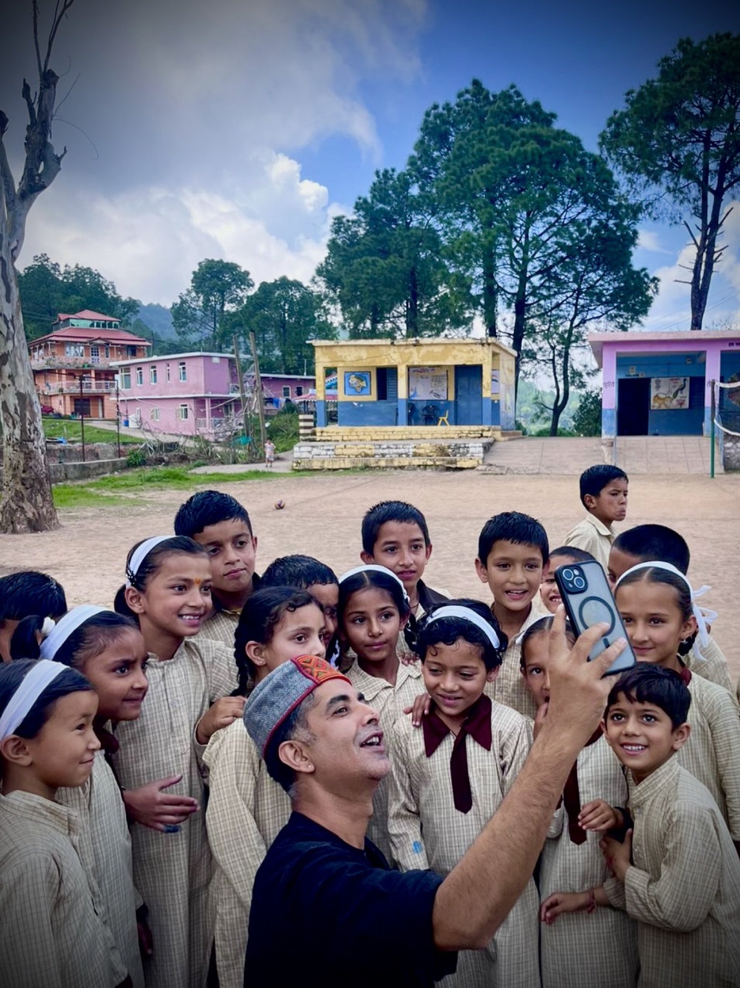 A group of schoolchildren crowded together, smiling at the camera