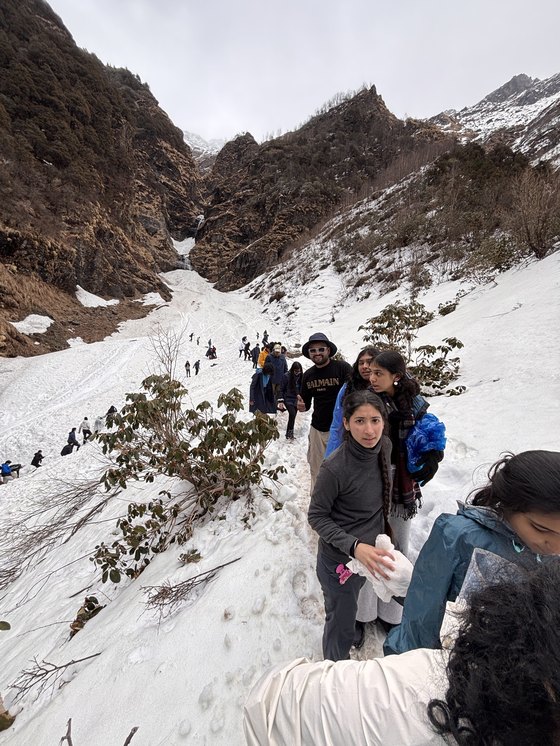 A group trekking through snow on a hill path
