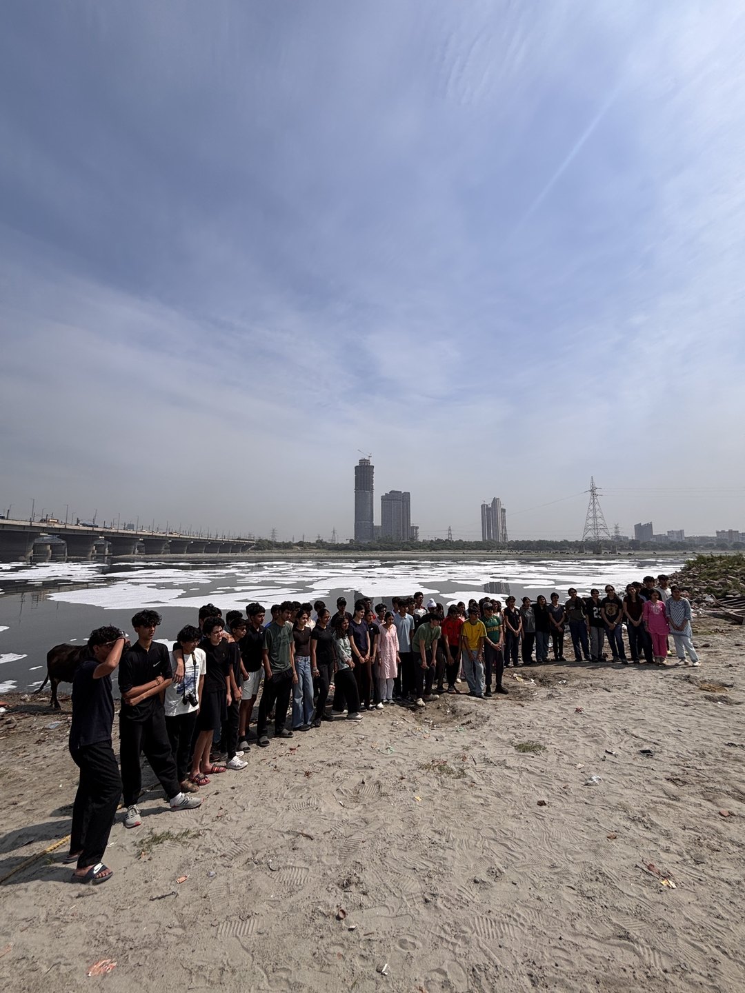 People gathered along the Yamuna below the city skyline