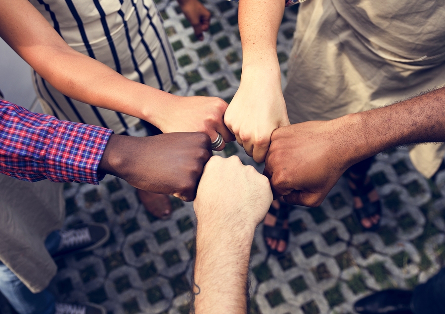Diversity hands fist bump for support and team-building